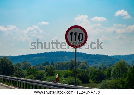 Speed limit sign against a blue sky.