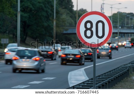 Speed limit sign with a traffic in the background