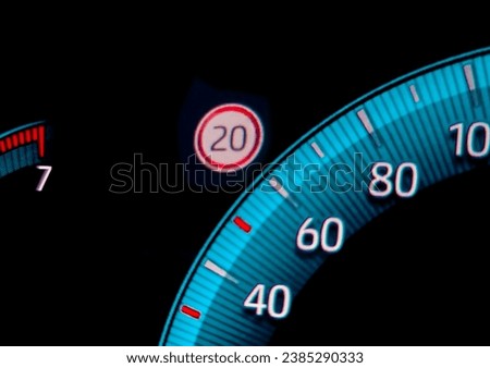 Speed limit warning close to speedometer indicator. Digital car dashboard closeup