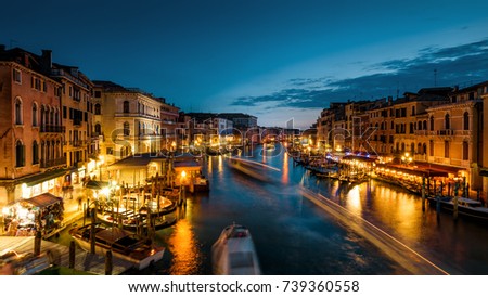 Speed motion on Grand Canal at night, Venice, Italy. Street nightlife and traffic. Panoramic view of night Venice. Romantic water trip in Venice at dusk. Panorama of waterfronts of Venice in evening.