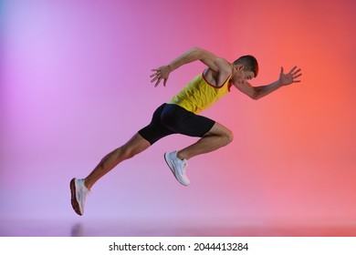 Speed. Run. Young Man Professional Athlete, Runner Training Isolated Over Gradient Studio Background. Maintaining Health And Strength. Concept Of Sport, Healthy Lifestyle, Motion. Copy Space For Ad