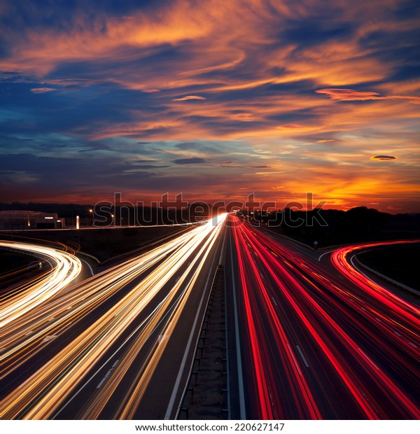 Speed\
Traffic at Dramatic Sundown Time - light trails on motorway highway\
at night,  long exposure abstract urban\
background
