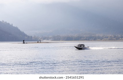 A speedboat cruises across the tranquil waters of Fraser Valley, BC, Canada, surrounded by picturesque mountains and lush forests. A serene and adventurous outdoor scene. - Powered by Shutterstock