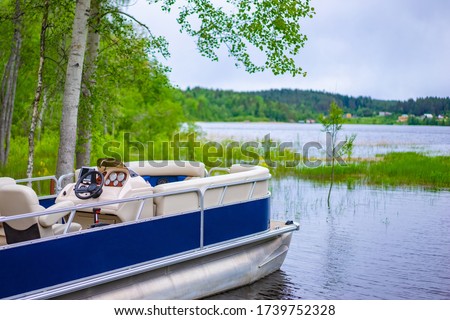 Speedboat on the background of a picturesque lake. Water recreation. Boating. Boat rental. Boat station. Water transport for walking.