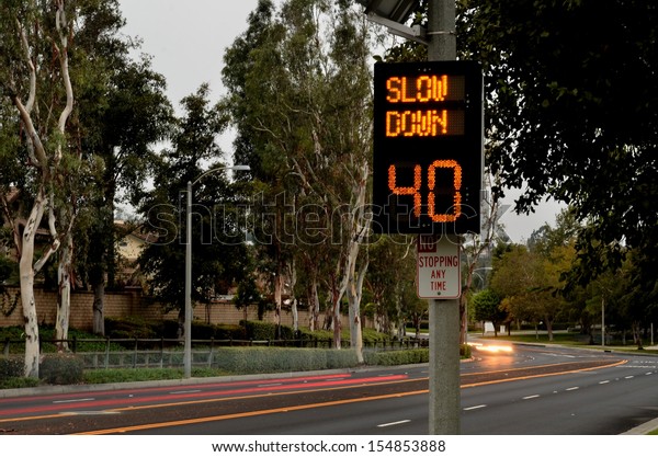 Speeding\
cars and traffic warning sign/Traffic Speed Zone.Illuminated\
traffic speed warning sign with speeding\
cars