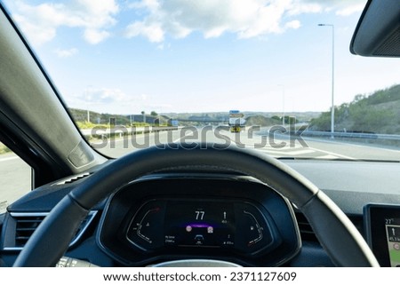 Speedometer in the car on the dashboard. The car's speedometer shows 77 Km's per hour (Seventy seven Miles per hour), with the empty highway in the background. Algarve, Portugal. Stok fotoğraf © 