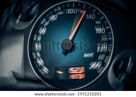 The speedometer of a modern car shows a high driving speed. Added motion blur.