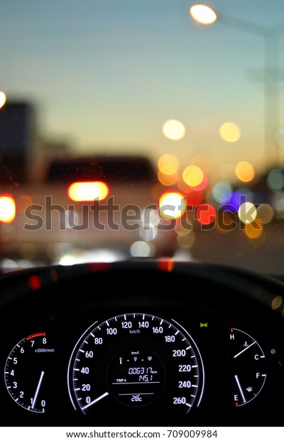 speedometer\
in modern vehicle car drive travel road trip in night city with\
blur bokeh traffic light on street\
background