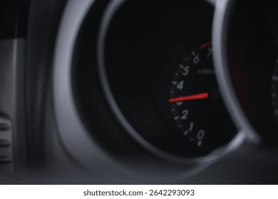 The speedometer on the car is predominantly black with a red indicator color.