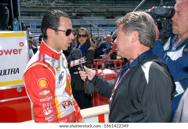 Speedway, IN, USA -\
May 24, 2013: Race driver Helio Castroneves gets interviewed before\
Carb Day practice for the Indy 500 at Indianapolis Motor Speedway\
in 2013.
