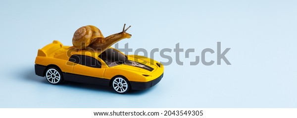 Speedy snail like car racer. Concept of speed\
and success. Concept of fast taxi or delivery. Yellow race car on\
light blue background. Banner, copy\
space