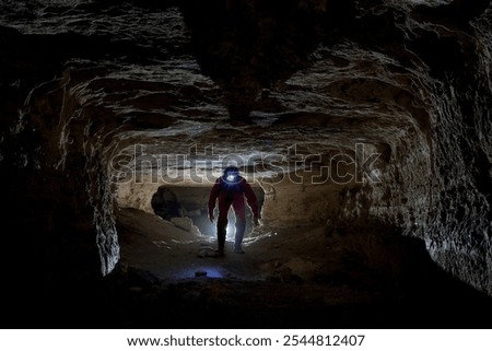 A speleologist does a survey in a large underground cave system.