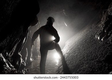 A speleologist explores an underground river in a vast karst cave system. - Powered by Shutterstock