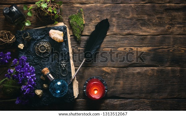 Spell book,
magic potions and other various witchcraft accessories on the
wizard table background with copy
space.