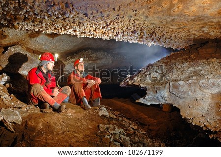 Spelunkers in cave admiring the stalactites