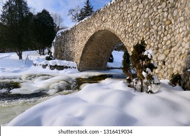 Spencer Creek Running Under A Stone Bridge At Webster Falls Conservation Area Park In Winter