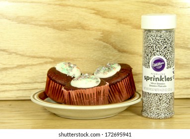 SPENCER , WISCONSIN - JANUARY 22, 2014 : Bottle Of Wilton Pearlized Sprinkles Next To Some Decorated Cupcakes. Wilton Has Been A Leading Provider Of Cake Decorating Supplies For Over 85 Years.