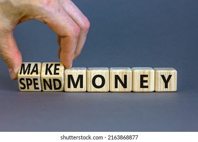Spend or make money symbol. Businessman turns cubes and changes concept words Spend money to Make money. Beautiful grey table grey background. Business spend or make money concept. Copy space.