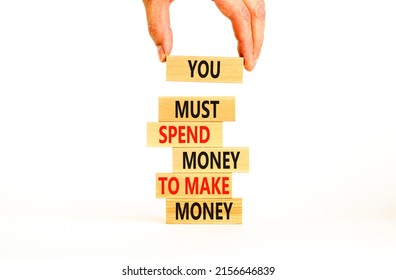 Spend and make money symbol. Wood blocks with words You must spend money to make money. Beautiful white table white background Businessman hand. Business spend and make money concept. Copy space.
