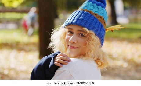 Spend Your Leisure Time Outside. Portrait Of A Beautiful Millennial Caucasian Girl Looking At Camera, Wearing Colorful Knitted Hat. High Quality Photo