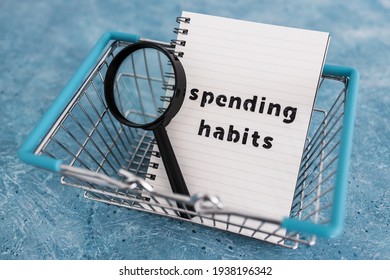 Spending Habits Text On Notepad With Shopping Basket And Magnifying Glass, Money And Consumer Behaviour Conceptual Image