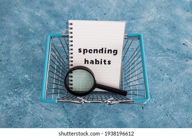 Spending Habits Text On Notepad With Shopping Basket And Magnifying Glass, Money And Consumer Behaviour Conceptual Image