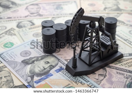 Spending or investment of a country's revenues from petroleum exports industry (Petrodollar). Oil pump jack and barrels on US dollar banknotes. Concept of crude oil production, petroleum industry.