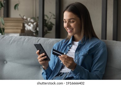 Spending money with pleasure. Happy young female client of reliable bank use card to buy order prepay goods online at web store via special app. Smiling millennial woman engaged in internet shopping