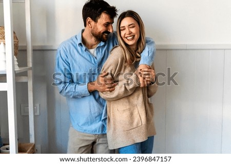 Spending nice time at home. Beautiful young loving couple bonding to each other and smiling
