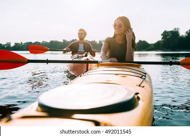 Spending Quality Time Together. Beautiful Young Couple Kayaking On Lake Together And Smiling 