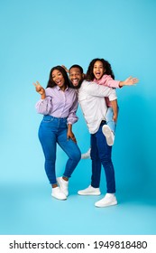 Spending Time With Family Is Fun. Full Body Length Of Excited African American Man, Woman And Girl Laughing And Posing Isolated Over Yellow Studio Wall. Cheerful Father Carrying His Daughter On Back