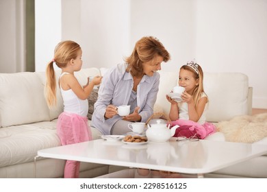 Spending time with her daughters. a grandmother and her granddaughters enjoying a tea party together. - Powered by Shutterstock