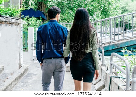 Spending time together. Beautiful well dressed couple walking together outdoors. Love, relationship, dating concept. Rear view. Horizontal shot