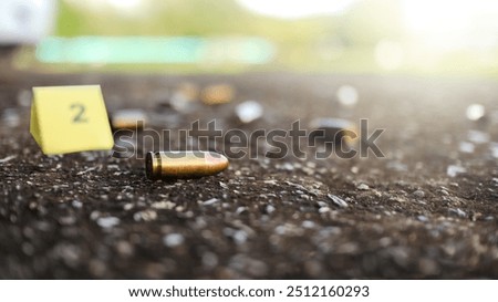 Spent bullet casing lying on dark ground with blur number 2 sign. Concepts of criminal investigations
