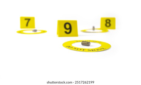 A spent bullet casing placed within a yellow circle, labeled with the text Evidence, Do Not Move, with a blurred number 9, 8 and 7 tag, set against a white background, concept of crime investigation.