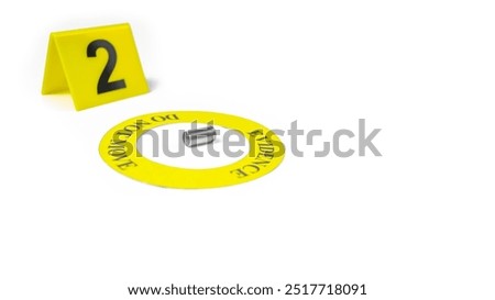 A spent bullet casing placed within a yellow circle, labeled with the text 