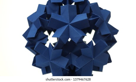 Sperical modular origami object. Close up blue origami ball isolated on white background. Japanese artwork and traditions.