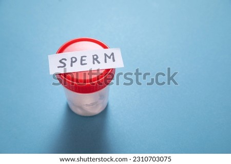 Sperm sample collection container on the blue background.