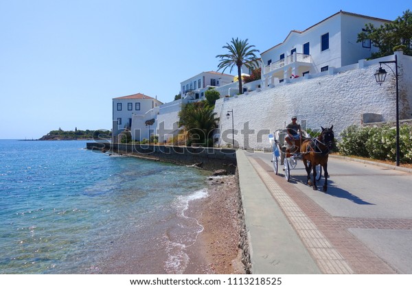 Spetses island, Saronic gulf / Greece
- June 02 2018: Photo of horse carriage in traditional promenade
street with picturesque character                  
