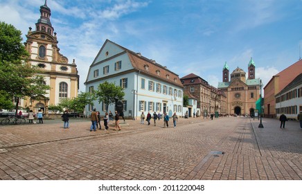 Speyer, Germany - May 2, 2014: Tourists walk in the mainstreet flanked with historical buildings and the great cathedral in the old centre of Speyer, Germany on May 2, 2014
