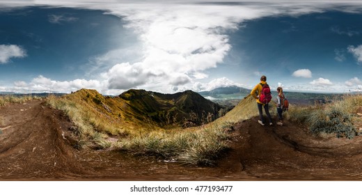 Spherical, 360 degrees, seamless panorama of the two ladies hikers standing on top of the mountain and enjoying volcanic valley view, Bali, Indonesia