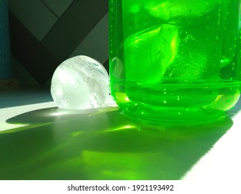 The Spherical Ice In The Green Glass And The Sparkle Of Sunlight That Shines Through It.