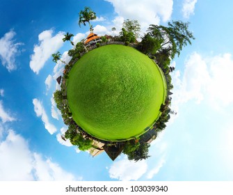 Spherical panorama of a green meadow with trees and buildings and blue sky with clouds