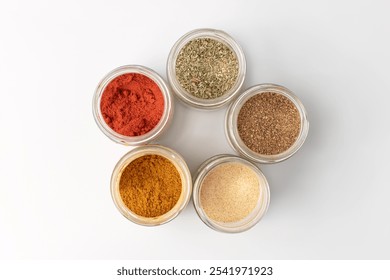 Spice powder in a glass jar, isolated on a white background. Various spicy spices close-up view from above - Powered by Shutterstock