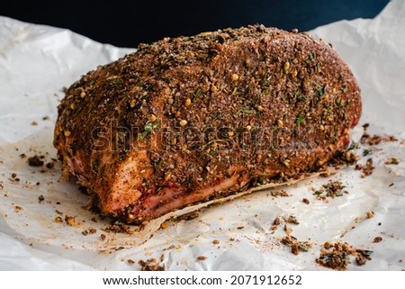 Spice Rubbed Raw Bone-in Standing Prime Rib Roast: Uncooked rib roast covered in a spice rub