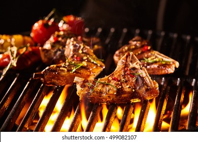 Запряженной вкусной баранины нарезать кусочки мяса с костями на гриле под огнем с жареными овощами в фоновом режиме