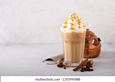 Spiced iced chai latte with whipped cream, seasonal fall drink
