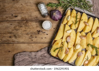 Spiced Pieces Of Raw Potato Prepared To Bake. Fresh Rosemary, Garlic, Sea Salt. Vegan Healthy Food Concept. Vintage Wooden Table, Top View