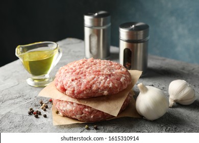 Spices and baking paper with minced meat on grey background, close up