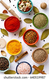 Spices in colorful bowls viewed from above. Various seasonings on a white background. Italian mix, cumin, chili pepper, curry powder, Himalayan salt, pepper, garlic, cinnamon, dried tomato. Top view - Shutterstock ID 640519987